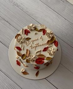 a white cake with red and green leaves on it