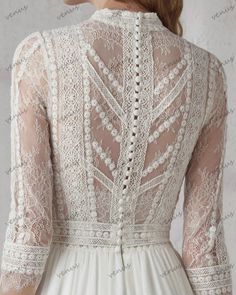 the back of a woman's wedding dress with sheer lace and beading on it