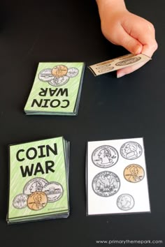 a child's hand is holding a coin and playing with some sort of game