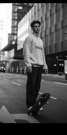 a young man is standing on his skateboard in the street