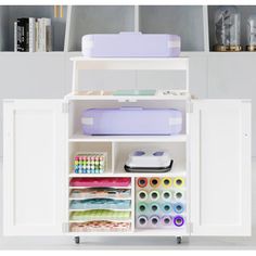 a white cabinet filled with craft supplies on top of a table