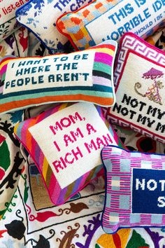 colorful pillows with embroidered sayings on them