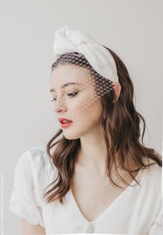 a woman wearing a veil and head piece