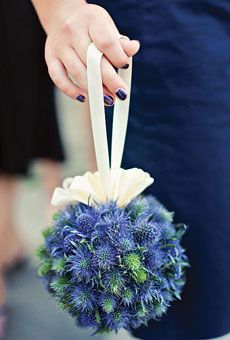 a woman is holding a blue and white bouquet