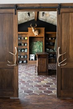 an open wooden door with deer antlers on the wall and shelves in the background