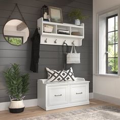 a white bench sitting under a window next to a mirror