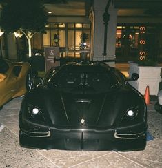 a black sports car parked in front of a building