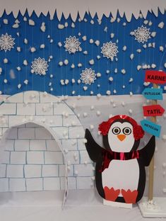 a penguin is standing in front of a paper cutout with snowflakes on it