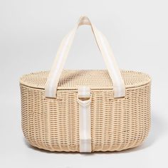 an empty wicker basket with white handles