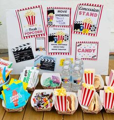 the table is set up with popcorn, hot dogs and sodas for movie night