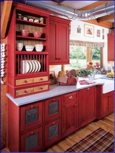 a kitchen with red cabinets and white counter tops