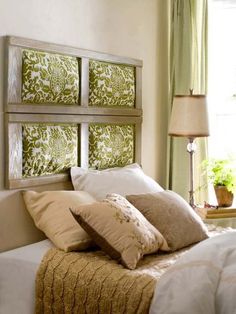 a bed with pillows and two framed pictures on the wall above it's headboard