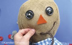 a person is making a scarecrow doll out of burlock and buttons on it