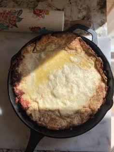 an omelet in a cast iron skillet sitting on a counter top next to a roll of toilet paper