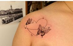 a woman's shoulder with two butterflies and a heart tattoo on the left side