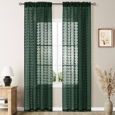 a living room with a large window covered in sheer curtains and green polka dot curtain panels