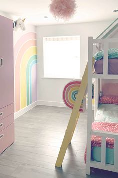 a child's bedroom with bunk beds and rainbow wallpaper