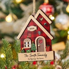 a red house ornament hanging from a christmas tree