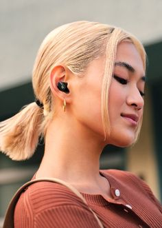 a woman with blonde hair wearing ear buds