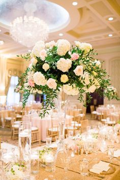 the centerpieces are arranged in tall vases with white and pink flowers on them