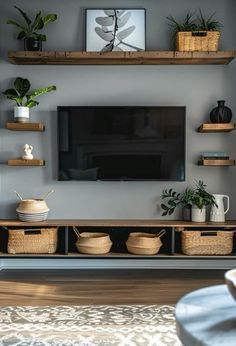 a flat screen tv sitting on top of a wooden shelf in a living room next to potted plants