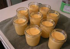 several jars filled with liquid sitting on top of a counter next to a towel covered table