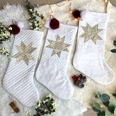 three white christmas stockings with gold stars on them