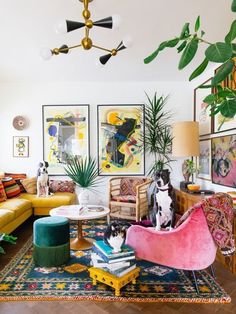 a living room filled with lots of furniture and plants on top of the rugs