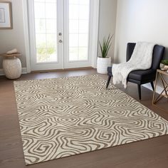 a living room area with a chair and rug on the hardwood floor next to a door