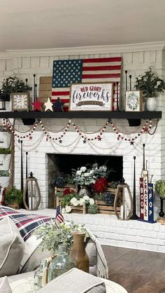 a living room decorated for the fourth of july with american flags and wreaths on the mantel