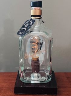 an empty glass bottle sitting on top of a wooden table