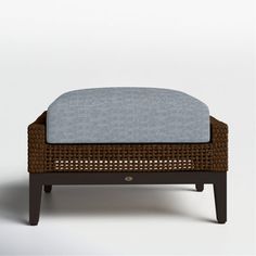 a footstool made out of wicker and blue cushion on an isolated white background