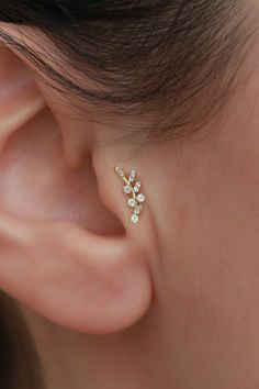 a close up of a person wearing a pair of ear piercings with flowers on them