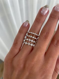 a woman's hand with three rings on her fingers and one ring in the middle