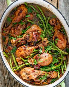 chicken and asparagus in a pan on a wooden table