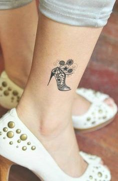 a woman's foot with a small tattoo on her left ankle and flowers in the boot