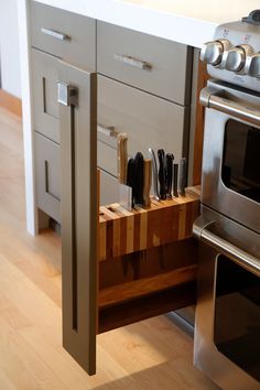 a kitchen with an oven, microwave and cutting board