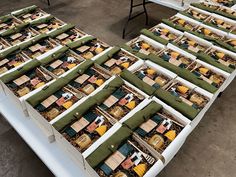 several rows of boxes filled with different types of items on top of a white table