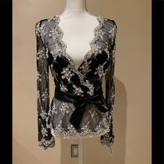 This Lace Blouse Is Fully Beaded With Pearls And Beads. It Has A Beautiful Scalloped Neckline, Cuffs, And Hem. It Is A Wrap Style Blouse And Has A Ribbon Wrap Around The Waist. Partially Lined. Chic Embellished Blouse For Wedding, Elegant Embellished Party Tops, Elegant Pearl-embellished Blouse For Wedding, Elegant Beaded Blouse For Wedding, Elegant Beaded Tops For Wedding, Elegant Long Sleeve Blouse With Pearl Embroidery, Designer Fitted Embellished Blouse, Designer Embellished Fitted Blouse, Elegant Long Sleeve Embellished Tops