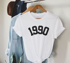 1990 Birthday Year Shirt, 1990 TShirt, 1990 Shirt for Women, Born In 1990 Shirt, Vintage 1990 BDay Gift For Him Her, 1990 Year Group Shirts This Bella Canvas Unisex T-shirt fits like a well-loved favorite. Super soft cotton and excellent quality print make one fall in love with it over and over again. Sizing is UNISEX. It will fit true to size for men, and a little more loosely and longer than your typical women's tee (great for wearing with leggings). Please size down if you prefer a more fitted look or if you are worried about it running small then size up. Please see the images for the size chart, and please don't hesitate to message me with any questions.  A rough guideline of sizes are X-Small (0-2) Small (4-6) Medium (8-10) Large (12-14) XL (16-18) Want this design on a different sty 49th Birthday Ideas For Women, The 1975 Shirt, Bday Gifts For Him, Number Shirt, Birthday Gift For Women, Group Shirts, Women Birthday, Birth Year, 45 Years