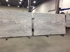 two white marble slabs sitting on top of each other in a room with lights above them