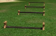 a row of wooden benches sitting on top of a lush green field