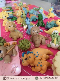 a table topped with lots of toy animals on top of a pink tray covered in frosting