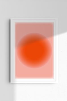 an orange and red circle on a white wall with a shadow from the light coming through it