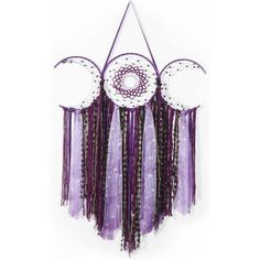 a purple and white dream catcher hanging on a wall next to a clock with two circles