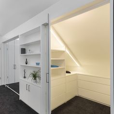 an empty room with white shelves and black carpeted flooring is seen in this image