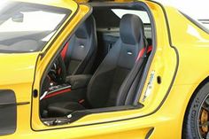 the interior of a yellow sports car with its doors open