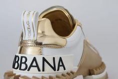 DOLCE & GABBANA

 Superbes toutes neuves avec étiquettes, baskets pour femmes 100% authentiques Dolce & Gabbana.

 Modèle : baskets Super Queen

 Couleur : Blanc et doré

 Matériel: 100% cuir

 Semelle : Caoutchouc

 Détails du logo

 Fabriqué en Italie

 Artisanat très exclusif et de haute qualité Luxury Leather Sneakers With Metallic Logo, Luxury Gold Sneakers With Rubber Sole, Gold Luxury Sneakers With Metallic Logo, Luxury Gold Sneakers With Metallic Logo, White And Gold Sneakers, Versace Pink, Blue Leather Jacket, Gold Sneakers, Polyester Jacket