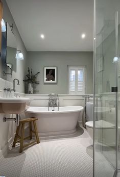 a bathroom with a tub, sink and toilet in it's corner area next to a walk - in shower