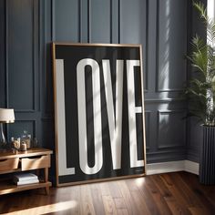 a black and white poster with the word love on it next to a wooden table